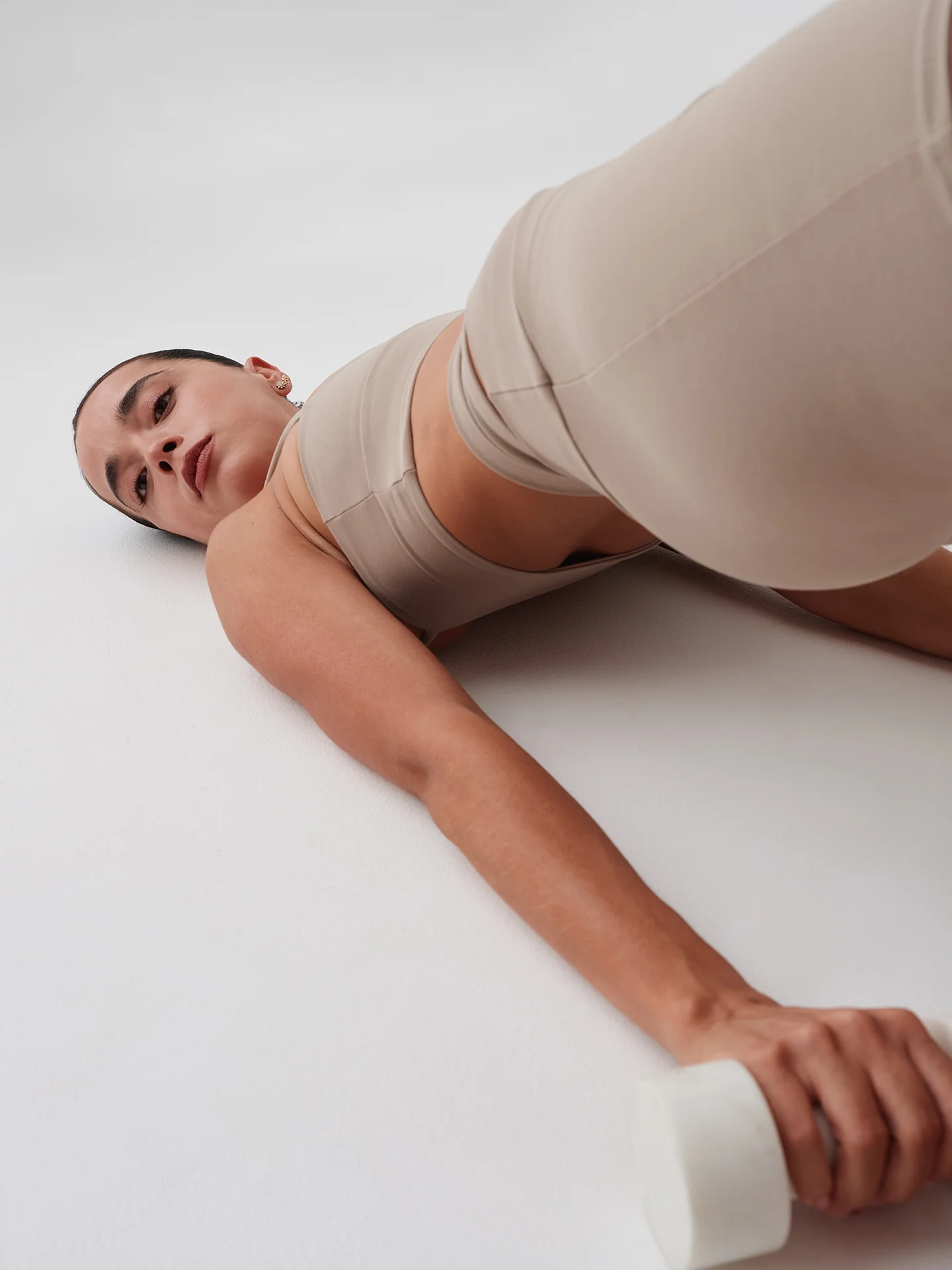 Woman in beige athletic wear showing back